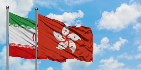 Iran and Hong Kong flag waving in the wind against white cloudy blue sky together. Diplomacy concept, international relations.