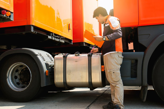 Truck Driver Inspecting Safety The Truck's Fuel Tank Of Semi Truck Trailer