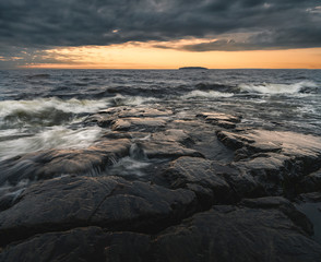 Moody sunset over northern shore with dramatic sky. Golden, blue and grey colors