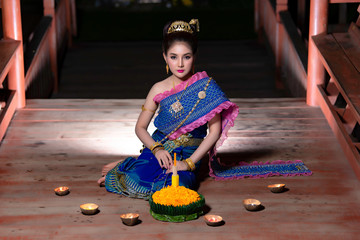 Portrait of beautiful asian woman in Thai dress traditional praying hold kratong for join loy...