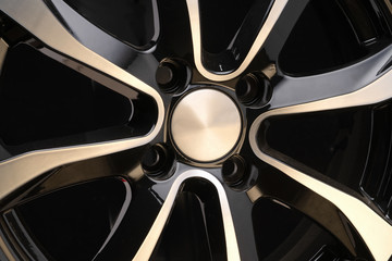 car alloy wheel close-up of the disc element, curves smooth lines of the wheel spokes, polished front surface. black background, concept