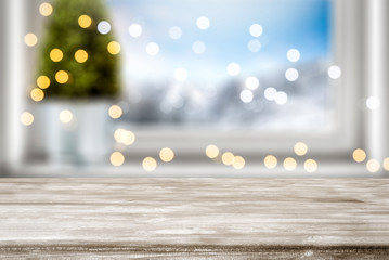 Table background of free space for your decoration and winter window background.Christmas tree.Winter landscape of mountains. Blurred lights.Copy space. 