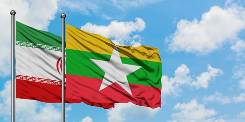 Iran and Myanmar flag waving in the wind against white cloudy blue sky together. Diplomacy concept, international relations.