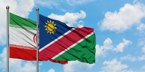 Iran and Namibia flag waving in the wind against white cloudy blue sky together. Diplomacy concept, international relations.