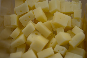 Manchego cheese cut into square pieces for foreground tasting