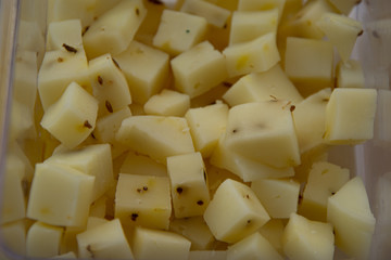 Manchego cheese cut into square pieces for foreground tasting