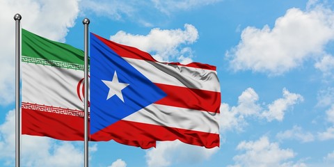 Iran and Puerto Rico flag waving in the wind against white cloudy blue sky together. Diplomacy concept, international relations.