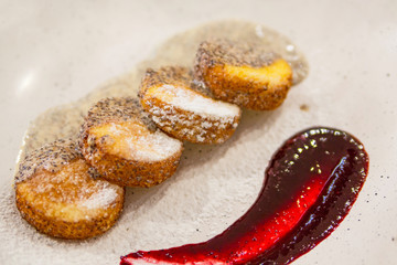 Cheesecake, fresh jam and poppy seed sauce. Cottage cheese pancakes or curd fritters decorated powdered sugar in plate close view. Healthy and diet breakfast.