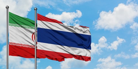 Iran and Thailand flag waving in the wind against white cloudy blue sky together. Diplomacy concept, international relations.