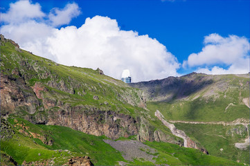 Mountaintop observatory with cloudy blue sky Mountain landscape. Elbrus region.