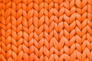 Texture of orange wool big knit blanket. Large knitting. Plaid merino wool. Top view