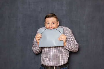 Portrait of fearful office worker biting folder nervously