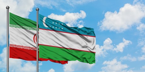 Iran and Uzbekistan flag waving in the wind against white cloudy blue sky together. Diplomacy concept, international relations.