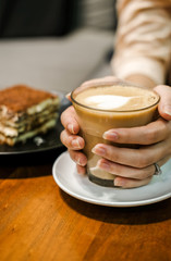 Woman enjoy the cup of coffee in her hands in coffee shop