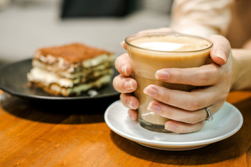Woman enjoy the cup of coffee in her hands in coffee shop