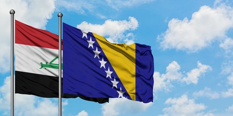 Iraq and Bosnia Herzegovina flag waving in the wind against white cloudy blue sky together. Diplomacy concept, international relations.