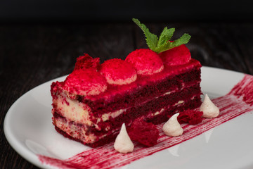 Plate with piece of delicious red velvet cake on dark wooden background