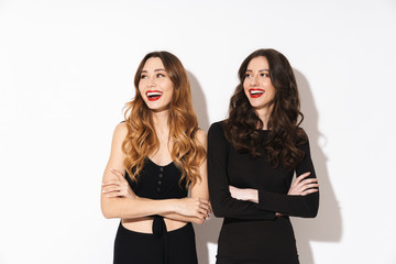 Image of two alluring women in black outfit smiling and looking aside