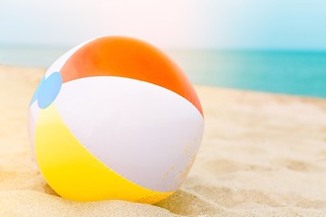 Background with a beach ball in the sand