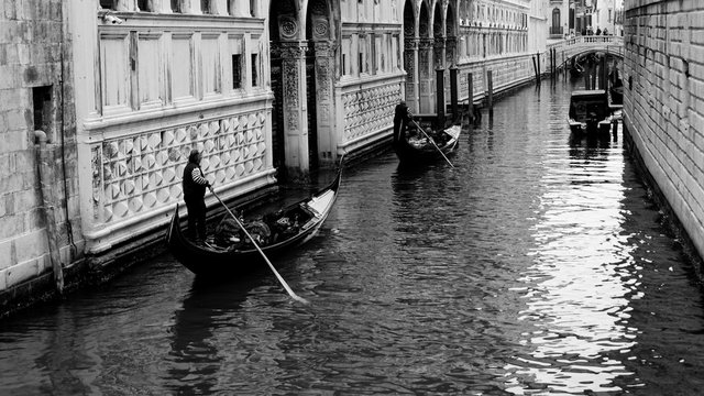 Fototapeta Black and white photo of gondola and gondolier taken in the beautiful city of Venice, Italy