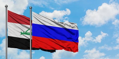 Iraq and Russia flag waving in the wind against white cloudy blue sky together. Diplomacy concept, international relations.