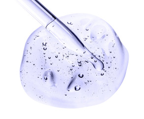 Liquid gel or serum on a screen of microscope white isolated background. Cosmetic pipette with transparent gel on white background. Serum oil in pipette. Cosmetic liquid dropper pipet with bubbles