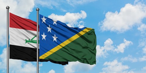 Iraq and Solomon Islands flag waving in the wind against white cloudy blue sky together. Diplomacy concept, international relations.