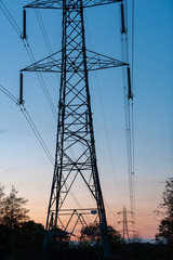 Electricity pylons with blue and orange sky in the background just after sunset