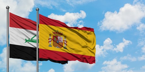 Iraq and Spain flag waving in the wind against white cloudy blue sky together. Diplomacy concept, international relations.
