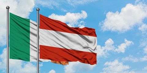 Ireland and Austria flag waving in the wind against white cloudy blue sky together. Diplomacy concept, international relations.