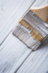 The process of painting paintbrush wooden surface of old(rustic) brown wood planks on white color. burned planks of pine tree. Close up