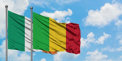 Ireland and Mali flag waving in the wind against white cloudy blue sky together. Diplomacy concept, international relations.