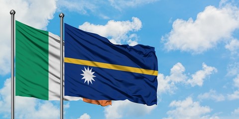 Ireland and Nauru flag waving in the wind against white cloudy blue sky together. Diplomacy...