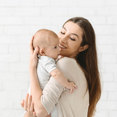Portrait of young mother cuddling her adorable little child