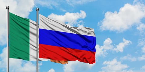 Ireland and Russia flag waving in the wind against white cloudy blue sky together. Diplomacy concept, international relations.