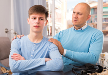 Father calming upset teenage son