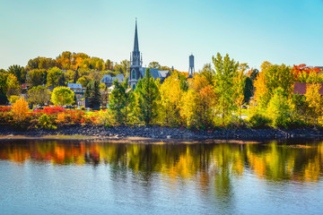Autumn Landscape View with Church and Colorful Trees Reflected in Water
