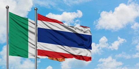 Ireland and Thailand flag waving in the wind against white cloudy blue sky together. Diplomacy concept, international relations.