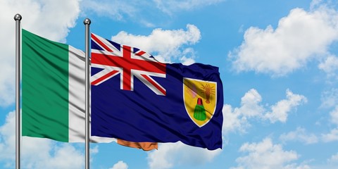 Ireland and Turks And Caicos Islands flag waving in the wind against white cloudy blue sky together. Diplomacy concept, international relations.