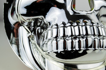 Close up of the teeth and cheek bones of a shiny chrome effect skull mask taken in a studio with studio lighting.