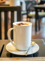 Hot milk foamy with bitter coffee, latte, in white cup for breakfast in restaurant
