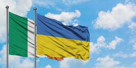 Ireland and Ukraine flag waving in the wind against white cloudy blue sky together. Diplomacy concept, international relations.