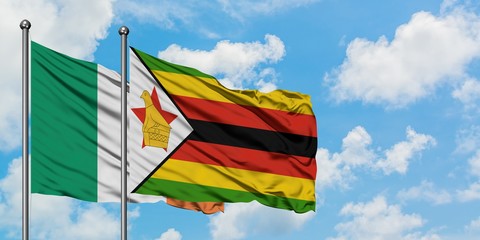 Ireland and Zimbabwe flag waving in the wind against white cloudy blue sky together. Diplomacy concept, international relations.