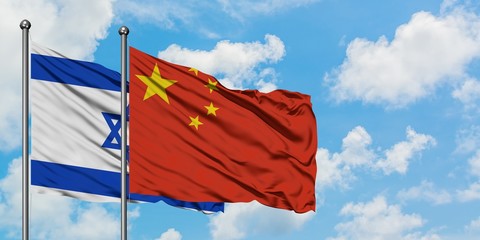 Israel and China flag waving in the wind against white cloudy blue sky together. Diplomacy concept, international relations.