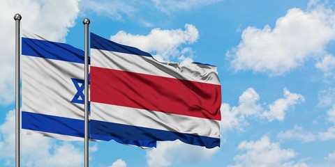Israel and Costa Rica flag waving in the wind against white cloudy blue sky together. Diplomacy concept, international relations.