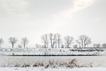 Fototapeta na wymiar winter landscape with trees and a canal in snow