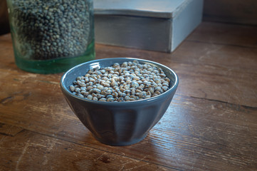 green dried letils in a grey ceramic bowl