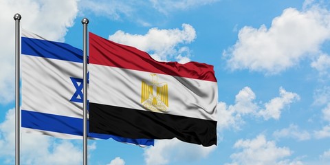 Israel and Egypt flag waving in the wind against white cloudy blue sky together. Diplomacy concept, international relations.