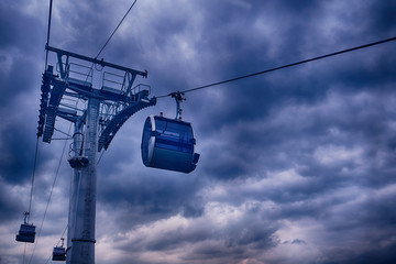 Cableway with cabs for transporting people against a stormy sky