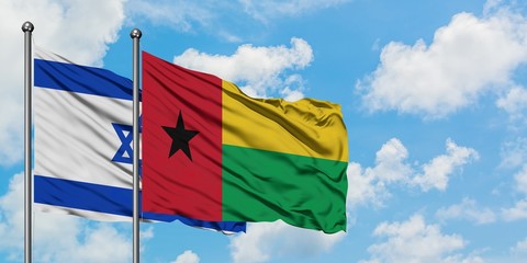 Israel and Guinea Bissau flag waving in the wind against white cloudy blue sky together. Diplomacy concept, international relations.